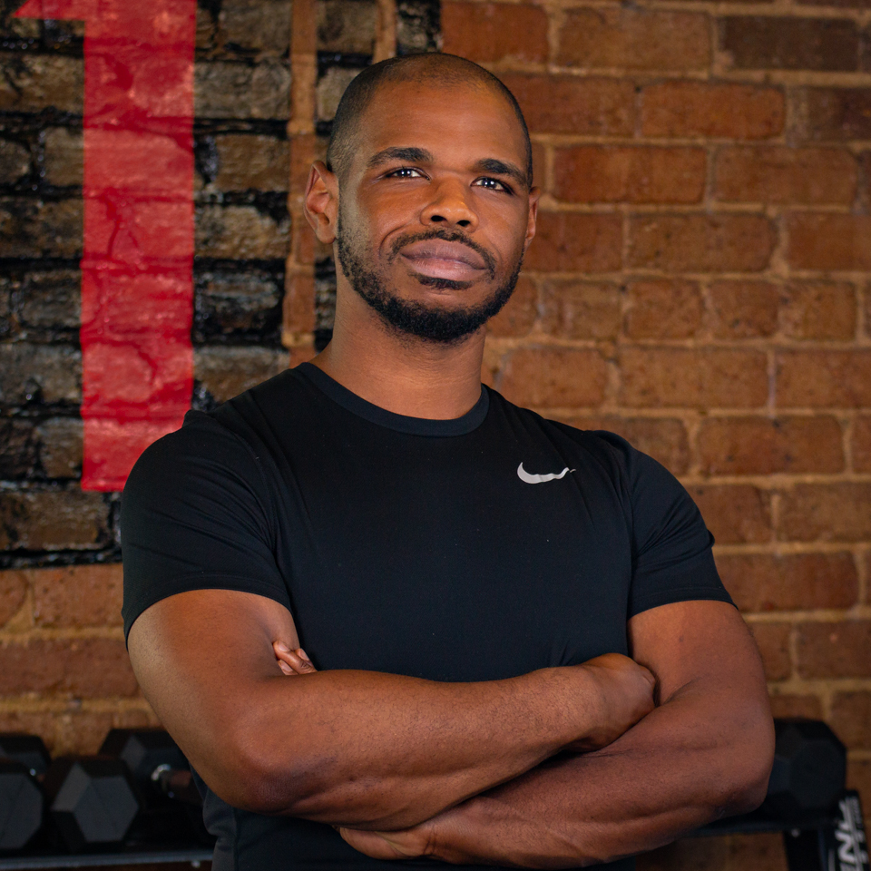 Approachable certified personal trainer in Knoxville, Jasen Bradley, smiling, wearing branded activewear